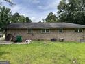 The home's rear exterior with functional AC units and a lush backyard at 3929 Rockey Valley Dr, Conley, GA 30288