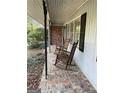 Comfortable front porch with brick floor featuring two classic rocking chairs at 276 Colewood Nw Way, Atlanta, GA 30328