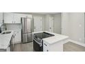 Bright, modern kitchen with white cabinets, stainless steel appliances, and white marble countertops at 1515 Jonesboro Se Rd, Atlanta, GA 30315