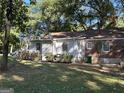 Exterior of home with green lawn, trees and garden beds at 718 N Hairston Rd, Stone Mountain, GA 30083