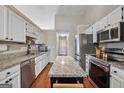 Modern kitchen featuring granite countertops, stainless steel appliances, and a central island at 1535 Smoke Hill Dr, Hoschton, GA 30548