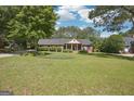 Traditional brick home with an expansive front yard, mature trees, and a charming, covered entrance at 109 Old Virginia Cir, Jonesboro, GA 30236
