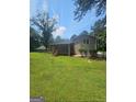 The home's expansive backyard includes a screened-in porch and a well-kept lawn at 7562 Asbury Manor, Lithonia, GA 30058