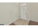 Bright foyer featuring tile flooring, a transom window, and a white front door at 686 Shore Ln, Lithonia, GA 30058