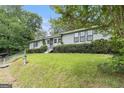 Exterior view of a charming single-story house surrounded by lush greenery and a vibrant lawn at 4705 Ernest Dr, Forest Park, GA 30297