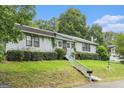 View of the home's exterior with green grass and a staircase that leads to the front door at 4705 Ernest Dr, Forest Park, GA 30297