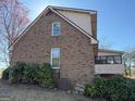 Brick house with a mix of textures, accented by lush green bushes and a modern AC unit at 291 Morgan Mill Rd, Brooks, GA 30205