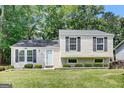 Inviting home featuring lush green lawn, beautiful shrubbery, and classic black shutters at 183 Wynnmeade, Peachtree City, GA 30269