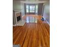 Spacious living room with refinished hardwood floors, a fireplace, and bay windows at 2587 Mead Ct, Jonesboro, GA 30236