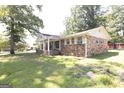 Single-story brick home with well-kept lawn, mature trees, and an inviting front entrance at 1112 Mealor Rd, Lawrenceville, GA 30043