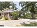 Charming brick home with mature landscaping, a covered porch, and a spacious driveway at 1112 Mealor Rd, Lawrenceville, GA 30043