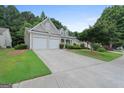 Charming home featuring a two-car garage, manicured lawn, and inviting curb appeal at 377 Avian Forest Dr, Stockbridge, GA 30281