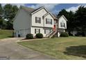 Attractive home featuring a two-car garage, stone accents, and a lush front yard with mature landscaping at 51 Estates Dr, Villa Rica, GA 30180