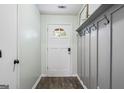 Bright foyer featuring stylish wood flooring, coat hooks, and a welcoming white front door at 200 Pine Tree Ln, Mcdonough, GA 30252