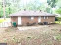 The back exterior has a small patio with chairs, two doors and an exterior air conditioning unit on the side at 10178 Top Tree Ct, Jonesboro, GA 30238