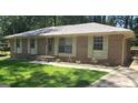 Charming brick home with a well-maintained lawn, complemented by a light green front door and traditional shuttered windows at 10178 Top Tree Ct, Jonesboro, GA 30238