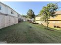 Large sloping backyard with grass and a wooden fence around the perimeter at 1650 Larkspur Trl, Conyers, GA 30012