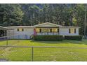 Charming single-story home featuring a quaint porch, green lawn, and fenced yard at 340 Loblolly Rdg, Locust Grove, GA 30248