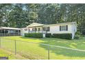 Charming single-story home featuring a covered parking and green lawn at 340 Loblolly Rdg, Locust Grove, GA 30248