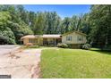 Charming single-Gathering home featuring a well-manicured lawn, mature trees, and inviting curb appeal at 207 Conkle Rd, Hampton, GA 30228