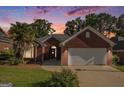Charming brick home with a well-manicured lawn at dusk, and a two-car garage at 286 Prominent Loop, Mcdonough, GA 30253
