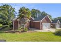 Attractive brick home with well-kept lawn and palm tree, featuring a two-car garage at 286 Prominent Loop, Mcdonough, GA 30253