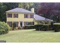 Attractive yellow home with red shutters surrounded by lush greenery at 150 Ashley Dr, Fayetteville, GA 30214