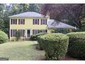 Charming two-story yellow home with red shutters and well-manicured front lawn at 150 Ashley Dr, Fayetteville, GA 30214