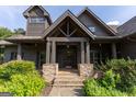 Inviting front entrance with stone steps leading to a covered porch with sturdy timber posts at 1051 Lake Rutledge Rd, Rutledge, GA 30663