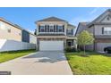 Two-story home featuring stone accents, a two-car garage, a green lawn, and neutral colored siding at 2384 Hastings Manor Ln, Hampton, GA 30228