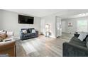 Comfortable living room featuring neutral paint, wood-look floors, and modern furnishings at 398 Patrick Henry Ct, Riverdale, GA 30274