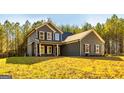 Charming two-story home featuring gray siding and black shutters, complemented by a well-manicured lawn at 5555 Hwy 155 N, Stockbridge, GA 30281