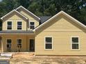 Newly constructed two-story home with bright yellow siding, showcasing a classic and inviting design at 5555 Hwy 155 N, Stockbridge, GA 30281