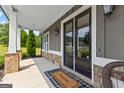 Inviting front porch featuring stone accents, stylish welcome mat, and a cozy seating area with a view at 195 Berry Hill Ln, Tyrone, GA 30290