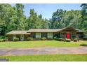 Charming ranch style home with lush greenery and mature trees surrounding the property at 2400 White Pine Ln, Mansfield, GA 30055