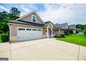 Home featuring a two car garage and a long drive-way and well manicured lawn at 328 Brookstone Dr, Carrollton, GA 30116