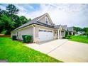 Home featuring a long drive-way and a two car garage and well manicured lawn at 328 Brookstone Dr, Carrollton, GA 30116