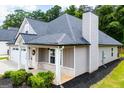 Home exterior featuring manicured lawn, chimney, a covered porch with brick and a two car garage at 328 Brookstone Dr, Carrollton, GA 30116