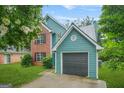 Charming two-story home with a brick and siding exterior, attached garage, well-maintained lawn, and lovely landscaping at 4753 Klondike Cv, Lithonia, GA 30038