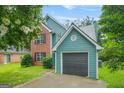 Charming two-story home with a brick and siding exterior, attached garage, well-maintained lawn, and lovely landscaping at 4753 Klondike Cv, Lithonia, GA 30038