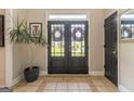 Inviting entryway with double glass doors, neutral paint, decorative plant, and stylish tile flooring at 130 Bexar Ct, Johns Creek, GA 30022