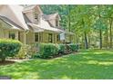 Lush green lawn leading to a quaint single-Gathering home with a covered front porch at 292 Selfridge Rd, Mcdonough, GA 30252