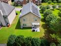 Aerial view of backyard with green lawn and trees, featuring solar panels on roof at 9132 Overlook Dr, Jonesboro, GA 30238