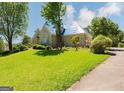 View of a two-story house with a large front lawn and boarded up windows and doors at 145 Windy Ridge Ct, Fayetteville, GA 30214