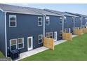 A neat backyard shows the exterior of the townhomes and green lawn at 11555 Kimberly Way, Hampton, GA 30228