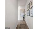 Entry hallway featuring hardwood floors and decorative artwork on white walls at 11555 Kimberly Way, Hampton, GA 30228