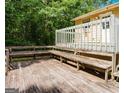 Spacious wooden deck featuring built in benches and wooden railings surrounded by mature trees at 4014 Oak Stone Dr, Douglasville, GA 30135