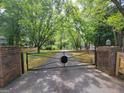 Long paved driveway past gated entrance bordered by mature trees at 45 Surrey Chase Dr, Social Circle, GA 30025