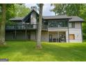 Backyard view of home featuring a deck overlooking a spacious lawn and mature trees at 45 Surrey Chase Dr, Social Circle, GA 30025