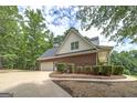 Exterior shot showing a two-car garage, well-kept landscaping, and a brick facade at 949 Amelia Rd, Locust Grove, GA 30248